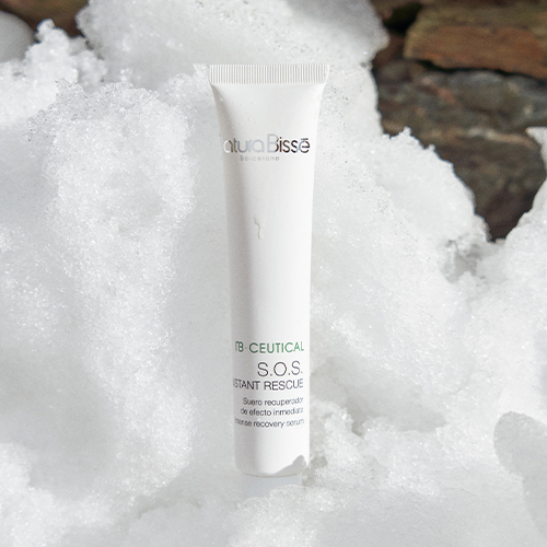 De witte tube van Natura Bissé S.O.S. Instant Rescue gepresenteerd in een sfeervolle setting van witte sneeuw en ijskristallen.