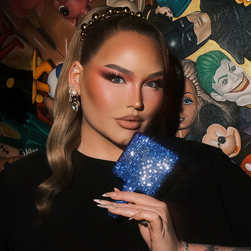 NikkieTutorials kijkt in de lichtblauwe Nimya handspiegel terwijl ze haar make-up bewondert.