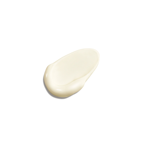 Een gladde swatch van de lichtbeige, romige zonnebrandvloeistof van Natura Bissé op een witte achtergrond, wat de vloeibare textuur laat zien.