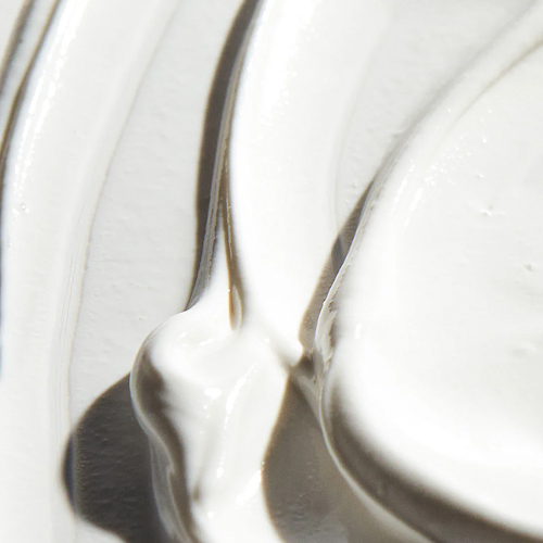 Extreme close-up van de rijke, witte crème-textuur van de Ultra Defense Moisturizer SPF 50.