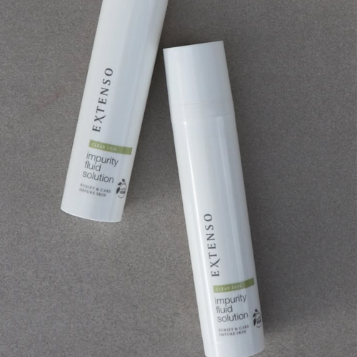Twee witte flacons van Extenso Impurity Fluid Solution tegen een grijze achtergrond.