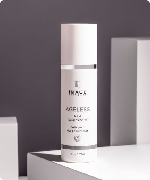 Vooraanzicht van de IMAGE Skincare AGELESS total facial cleanser in een witte pompflacon, gepresenteerd in een minimalistische studio-setting.