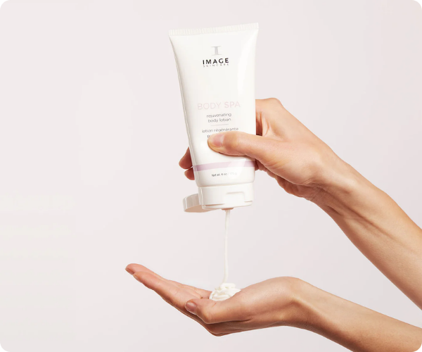 Een witte tube IMAGE Skincare Body Spa rejuvenating body lotion waaruit een dunne straal witte crème in een open handpalm wordt geknepen.