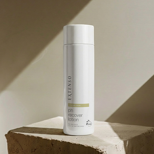 Extenso pH Recover Lotion flacon op een stenen ondergrond met schaduwspel.