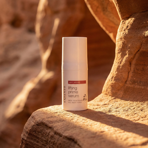 Het Extenso lifting prime serum flacon op een zonovergoten rotsachtige achtergrond met warme sfeerverlichting