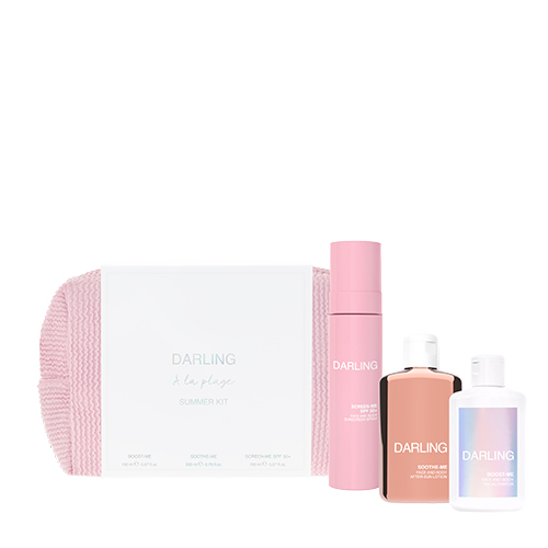 Een productfoto op een witte achtergrond van de Darling A la plage Summer Kit. De set bestaat uit een roze, wafel geweven toilettas, een roze sprayfles met SPF 50+, een koperkleurige fles met aftersun en een witte fles met tan activator.