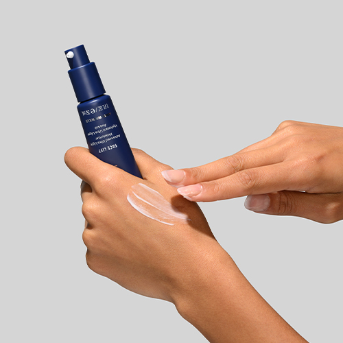Handen die de blauwe pompflacon van de HydroPeptide Face Lift Moisturizer vasthouden en een lichte hoeveelheid witte gezichtscrème op de handrug testen.