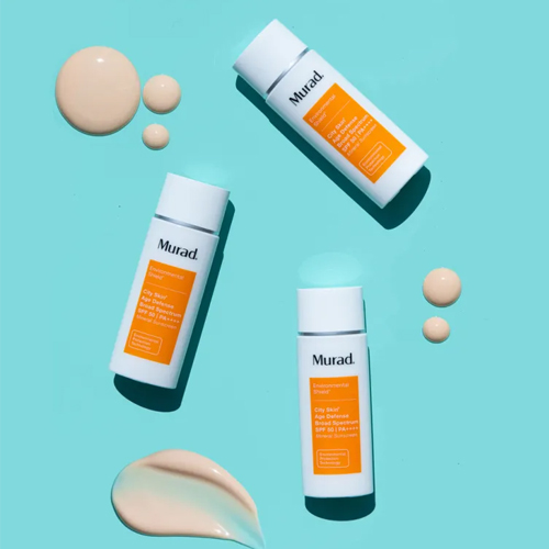 Textuur en druppels van Murad City Skin Age Defense SPF 50 op blauwe achtergrond