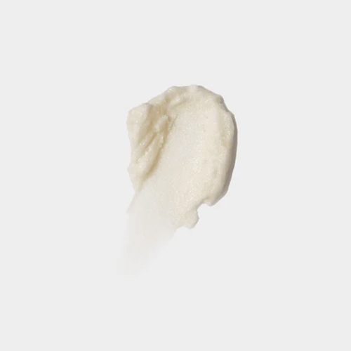 Textuur veeg van een exfoliërende, korrelige lipscrub op een egale lichtgrijze achtergrond