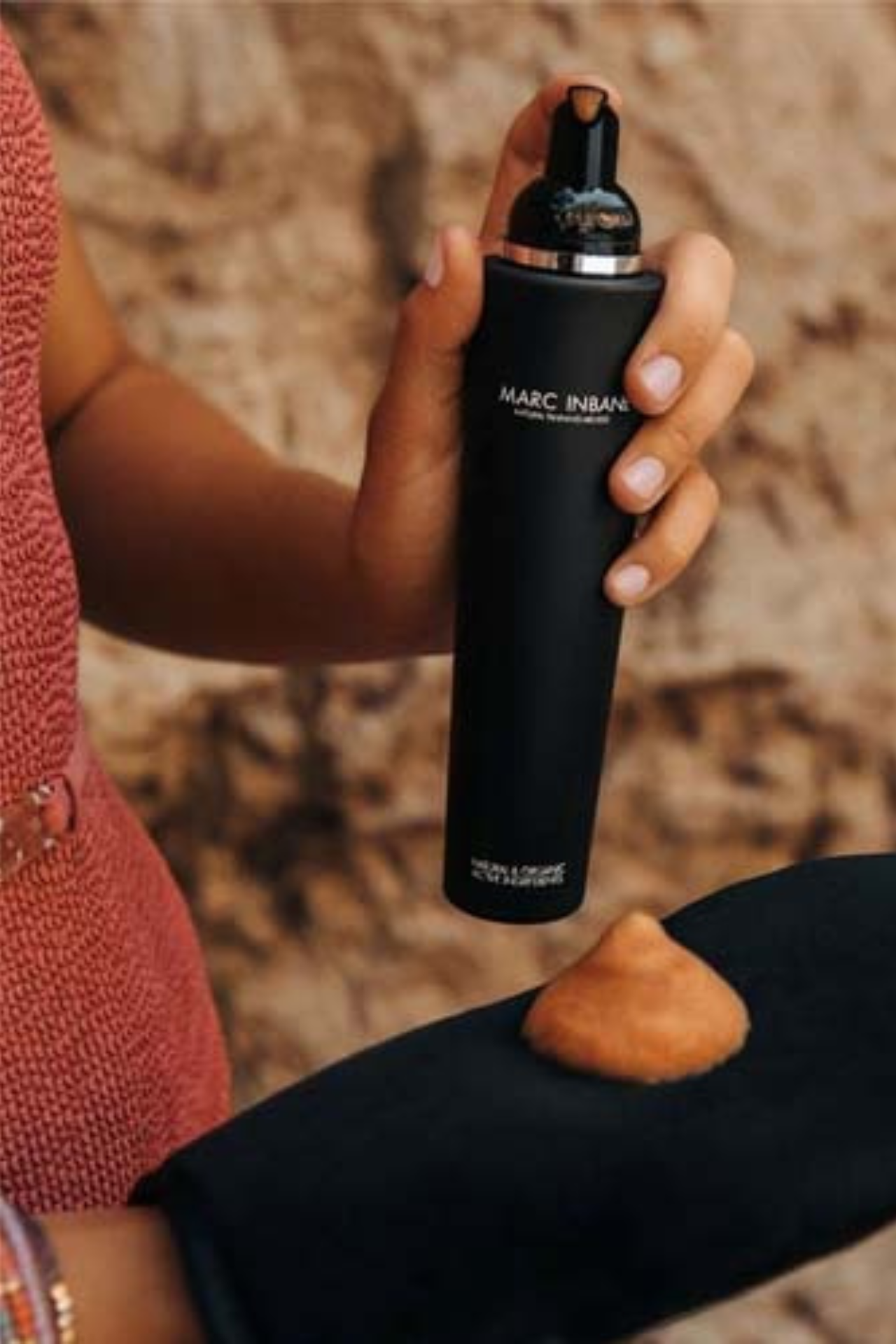Een persoon brengt Marc Inbane tanning mousse aan op een zwarte tanning glove.