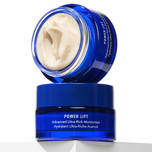 Twee blauwe potten HydroPeptide Power Lift op elkaar gestapeld met de open bovenkant vol crème.