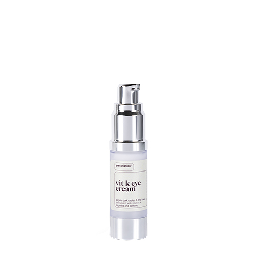 Een flesje Prescription Vitamin K Eye Cream zonder dop waardoor het zilveren pompje zichtbaar is op een witte achtergrond