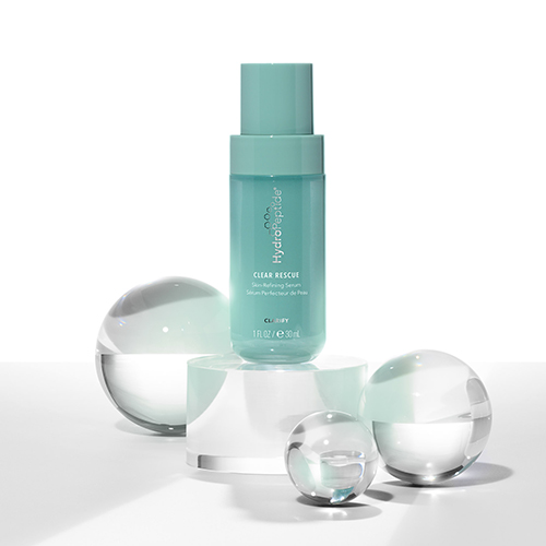 Turquoise flesje HydroPeptide Clear Rescue Serum gepresenteerd op glazen bollen en een witte ondergrond