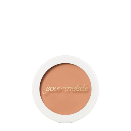 Een ronde compactdoos van Jane Iredale Enlighten Concealer in Medium Intense Peach op een witte achtergrond. Bevat een egale, warme perzikroze concealertint met het merklogo op de voorkant.
