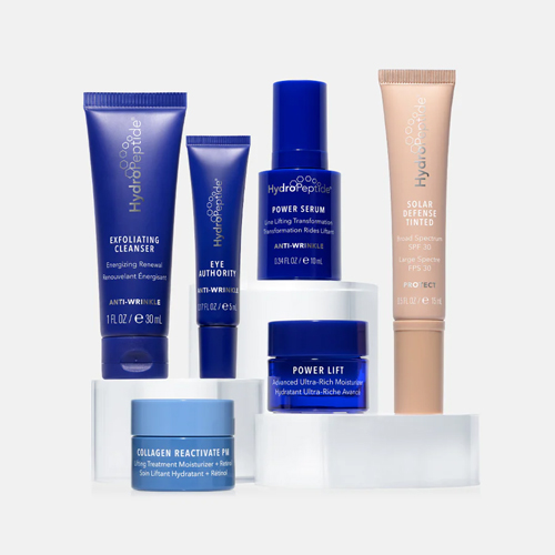De zes travel-size producten uit de HydroPeptide Age Reversal set los gepresenteerd, waaronder de Exfoliating Cleanser, Power Serum, Eye Authority, Power Lift, Collagen Reactivate PM en Solar Defense Tinted.