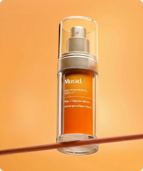 Oranje Murad Vita-C Glycolic Serum pompflacon op een oranje achtergrond met een dunne lijn
