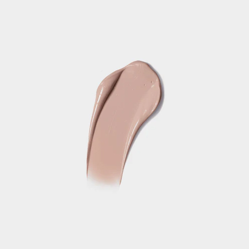Textuur swatch van een zachte, vloeibare beige getinte zonnebrandcrème op een egale grijswitte achtergrond