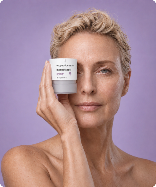 Een vrouw houdt een potje met mesoestetic exopeptide serum voor een van haar ogen tegen een lichte paarse achtergrond