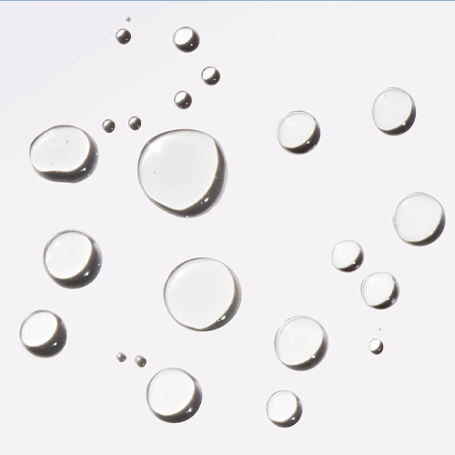 Close-up van transparante, vloeibare druppels van de Protect and Refresh Mist op een witte achtergrond.