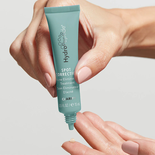 Een tube HydroPeptide Spot Correction Acne Eliminator Treatment in de hand met een druppel op de vinger