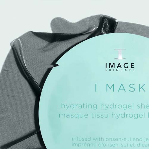 Een close-up van het grijze, glanzende hydrogel materiaal van het masker dat gedeeltelijk achter de lichtblauwe verpakking vandaan komt.