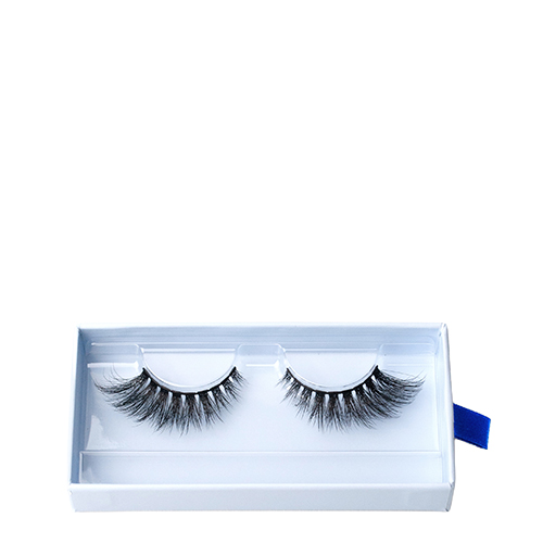 Een foto van de verpakking van Nimya by NikkieTutorials wimpers. De blauwe doos toont een set volle, zwarte nepwimpers met een blauw lipje. Witte achtergrond.