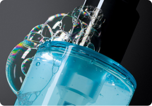 Een blauwe fles van Skinceuticals met schuimende bellen erbovenop voor reiniging en tonificatie