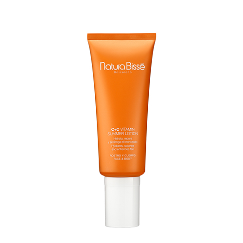 Een grote oranje tube Natura Bissé C+C Vitamin Summer Lotion voor gezicht en lichaam met een witte dop.