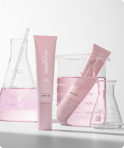 Hydropeptide restore productlijn met roze hydraterende skincare tubes en laboratorium glaswerk met vloeistof