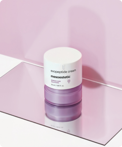Een potje met mesoestetic exopeptide cream op een spiegelend oppervlak met een zachtroze achtergrond