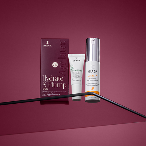 Luxe sfeerfoto van de IMAGE Skincare Hydrate and Plump Duo set op een glazen plateau met dieprode achtergrond