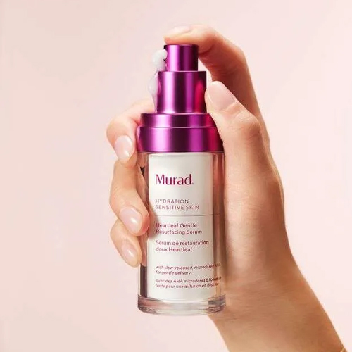 Hand die het pompje indrukt van een flacon Murad Heartleaf Gentle Resurfacing Serum