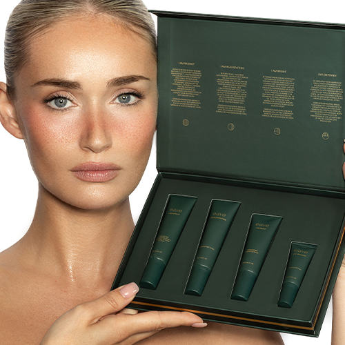 Een vrouw met een natuurlijke glow houdt de geopende EAVE Discovery Set vast, waarin de vier verschillende huidverzorgingsproducten overzichtelijk gepresenteerd worden.