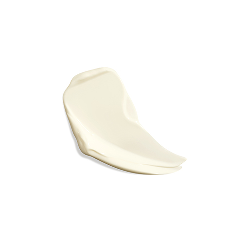 Een uitgesmeerde druppel van de Natura Bissé SPF 50 zonnebrandcrème, tonend hoe de substantie eruitziet op een witte ondergrond.