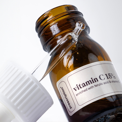Close-up van de glazen pipet en het amberkleurige flesje van het prescription vitamin c 15 procent serum