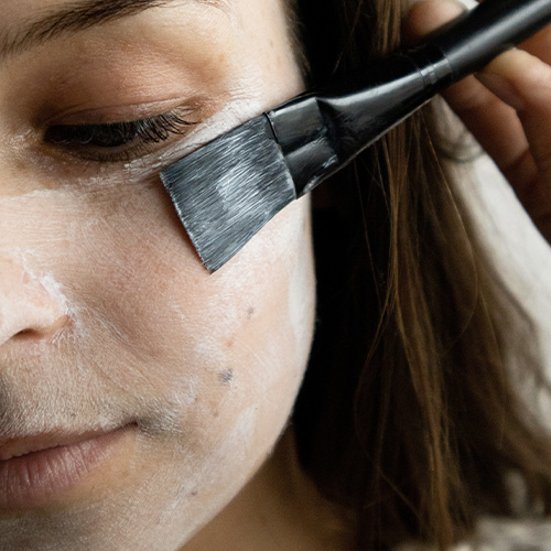 Zachte applicatie met een gezichtsmasker facial-mask-borstel