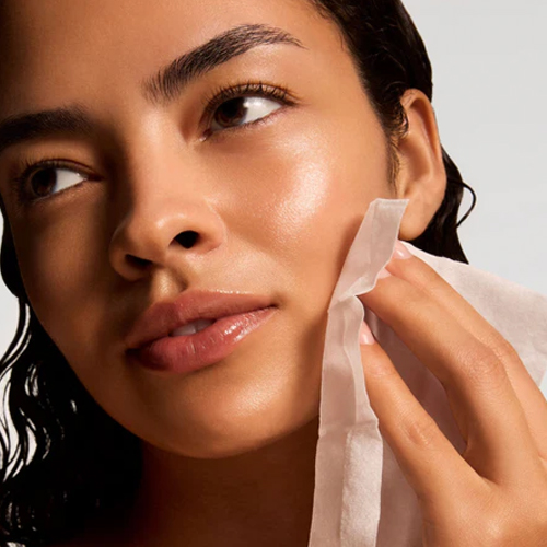 Close-up van een model met een stralende, gehydrateerde huid die haar gezicht verzorgt met een iS Clinical Active Peel System treatment pad