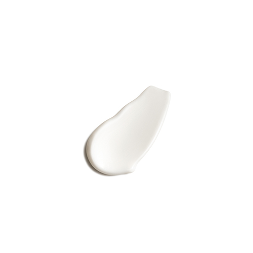 Een kleine, dikke en asymmetrische klodder ondoorzichtige witte cosmetische lotion of crème, gezien van bovenaf tegen een witte achtergrond.