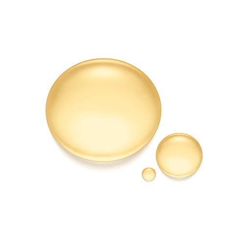 Drie ronde druppels van de vloeibare, goudkleurige zelfbruiner vloeistof op een witte ondergrond.