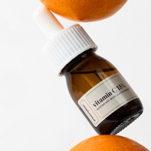 Sfeerbeeld van het prescription vitamin c 15 procent serum gepositioneerd tussen verse sinaasappels