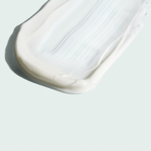 Een strijkende swatch van de rijke, witte crème-textuur van de intense moisturizer.