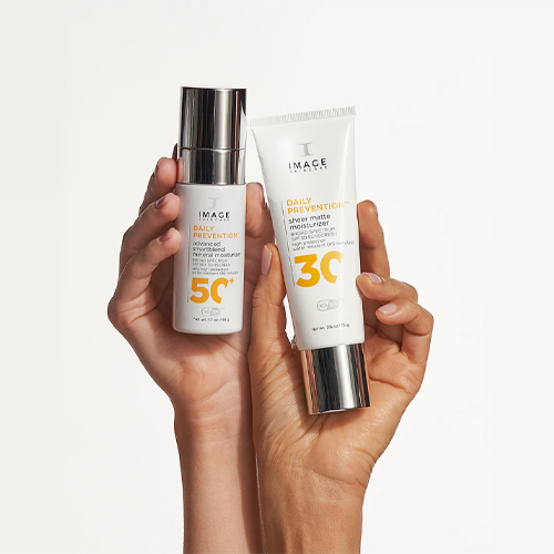 Twee handen die de Daily Prevention Advanced SmartBlend Mineral Moisturizer SPF 50+ en de Sheer Matte Moisturizer SPF 30 vasthouden tegen een witte achtergrond.