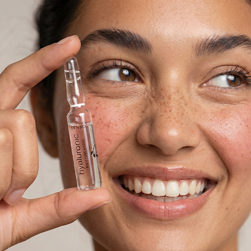 Model die de verpakking van Extenso Ampoule Hyaluronic vasthoudt.