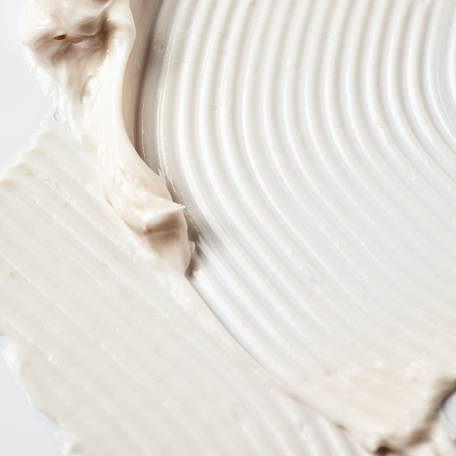 Een gedetailleerde close-up van de dikke, romige witte textuur van de IMAGE Skincare IMAGE MD balm met een golvend patroon.