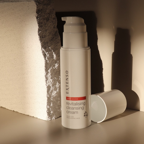 Extenso anti aging revitalising cleansing cream flacon met losse dop naast een ruwe steen met schaduwen