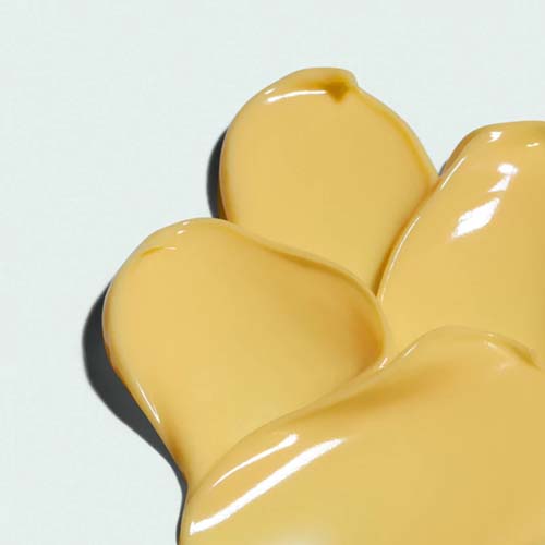 Een gedetailleerde macro-opname van de rijke, donker gele textuur van de IMAGE Skincare ORMEDIC Balancing Bio-Peptide Crème.