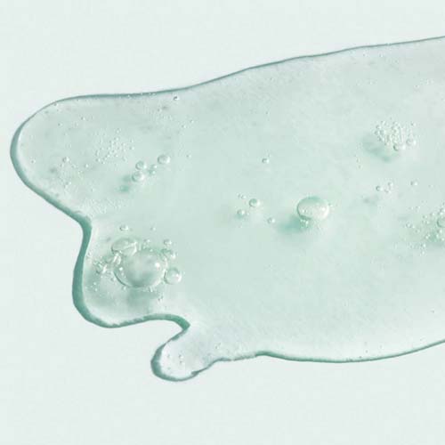 Een close-up van de lichte, waterige en transparante vloeistof van het ORMEDIC Balancing Antioxidant Serum met kleine luchtbelletjes.