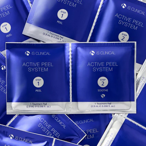 Een verzameling van koningsblauwe iS Clinical Active Peel System sachets met op de voorgrond de duo-verpakking van stap 1 en stap 2