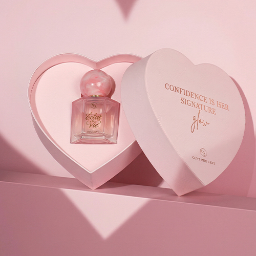 De Éclat de Vie parfumflacon gepresenteerd in een geopende, hartvormige roze doos met de tekst "Confidence is her signature glow".