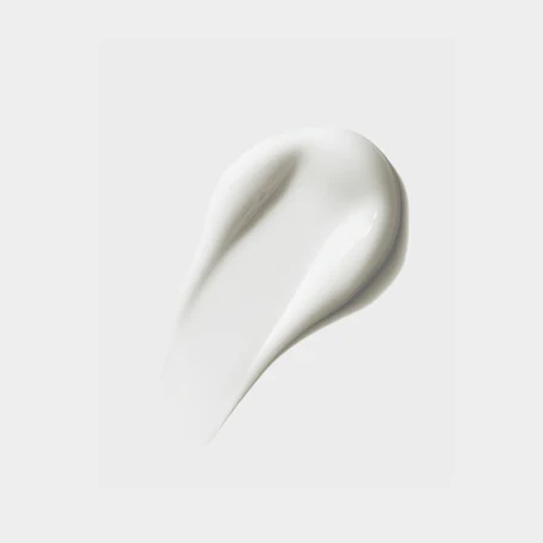 Textuur veeg van een gladde, romige witte gezichtscrème op een egale lichtgrijze achtergrond